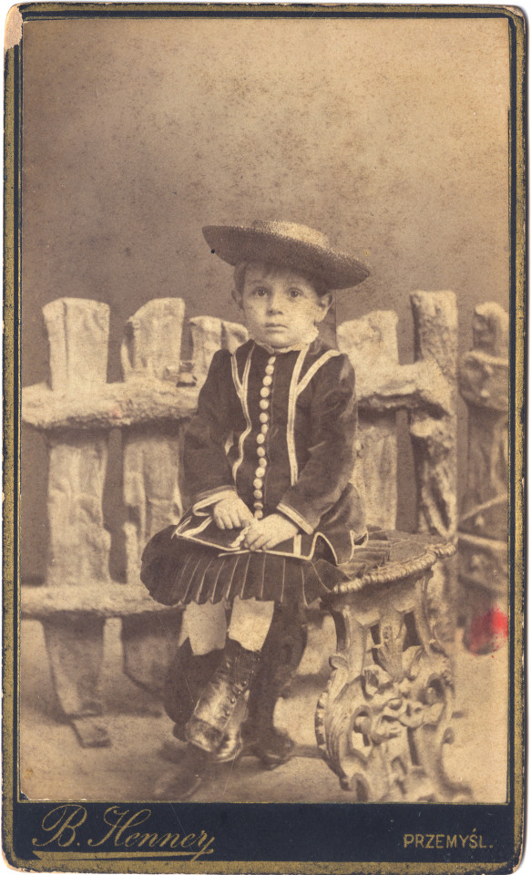 Zdjęcie przedstawiające małego siedzącego chłopca.