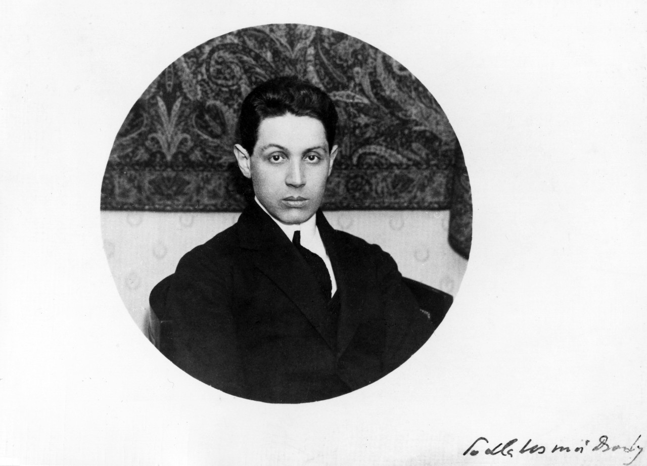Karta papieru z naklejonym okrągłym portretem młodego mężczyzny podpisana w prawym dolnym rogu.