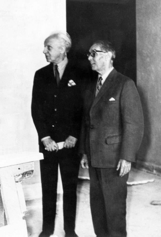 Czarno białe zdjęcie stojących dwóch mężczyzn.
