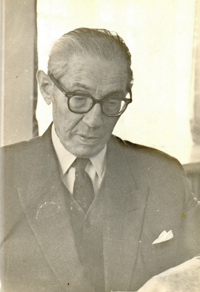 Staroświeckie zdjęcie w sepii starszego mężczyzny w okularach i krawacie.
