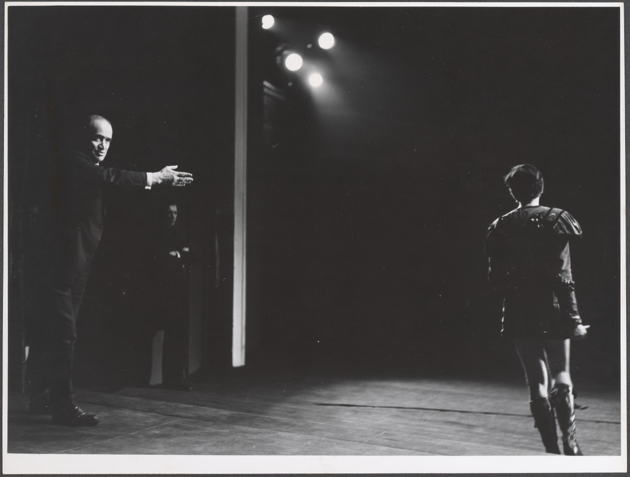 Na czarno-białym zdjęciu aktorzy na scenie podczas spektaklu Irydion.