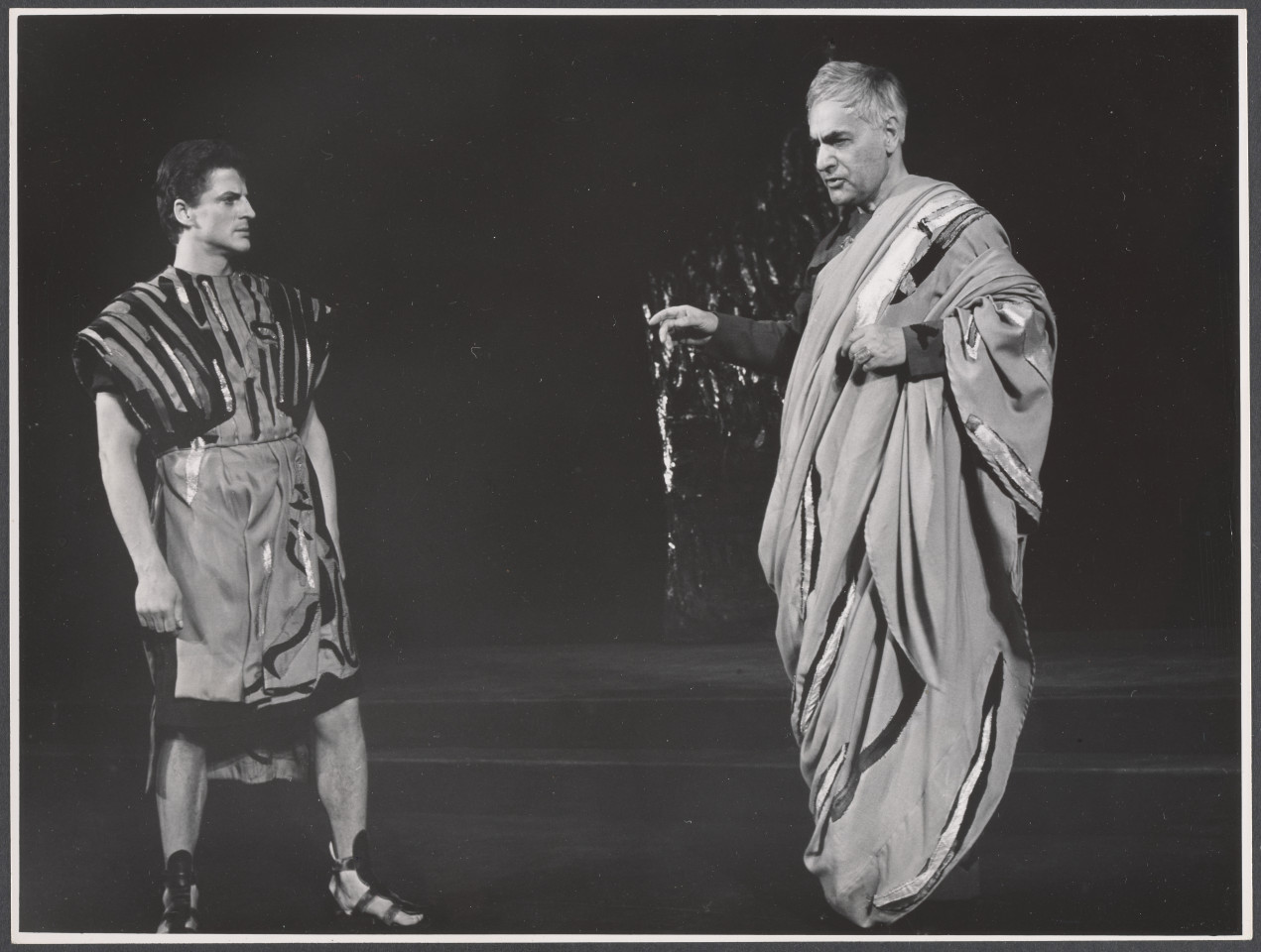 Na czarno-białym zdjęciu para aktorów na scenie w rolach podczas spektaklu Irydion.