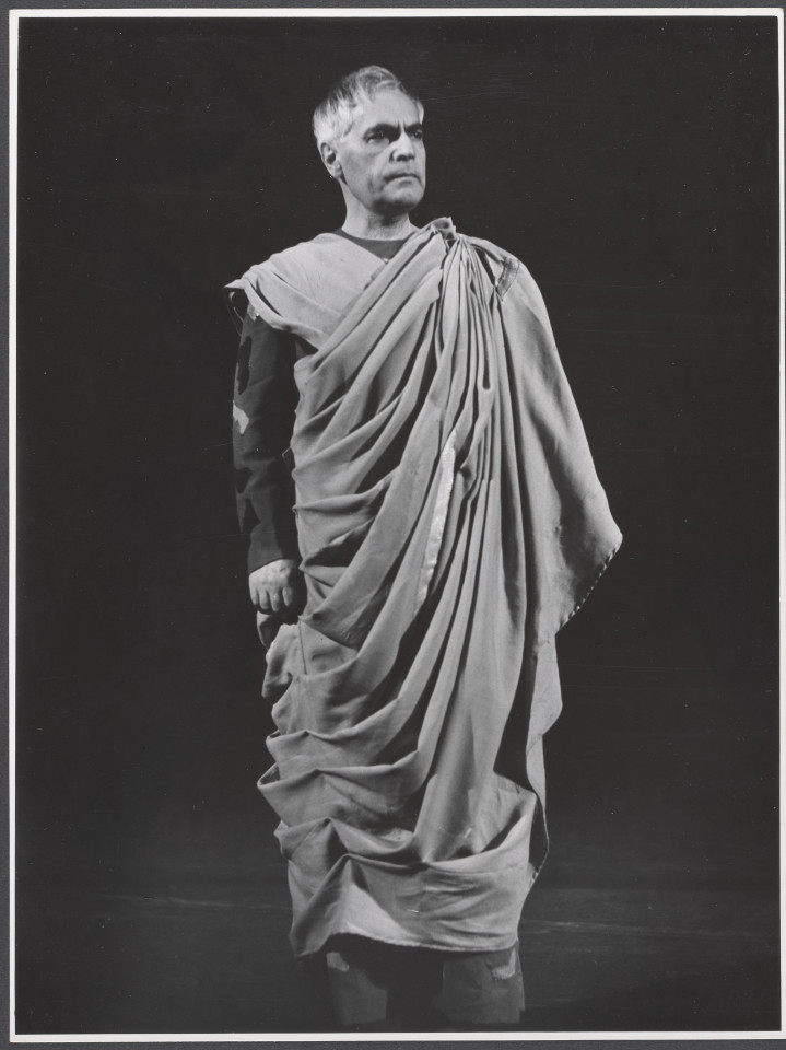 Na czarno-białym zdjęciu aktor na scenie w roli Ulpianusa podczas spektaklu Irydion.